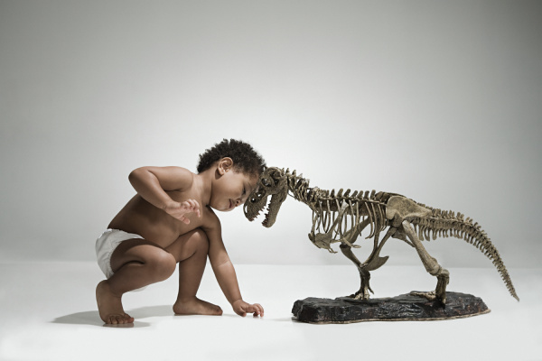 toddler with a dinosaur skeleton