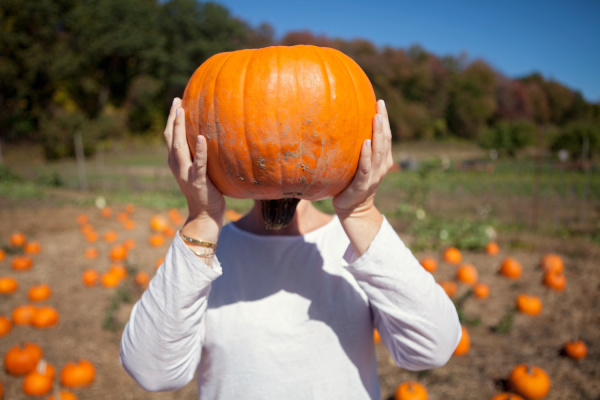 person holding a pumpkin in front