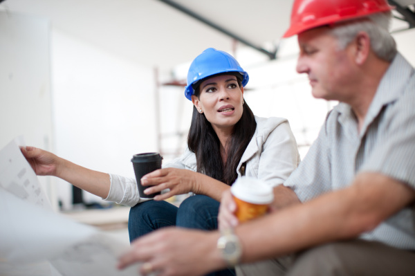 male and female construction workers sitting
