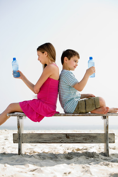 girl and boy holding bottles of