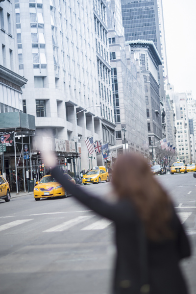 young woman hailing a yellow cab