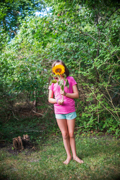 young girl holding sunflower in front