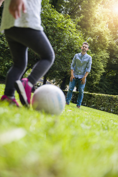 father and daughter playing football in