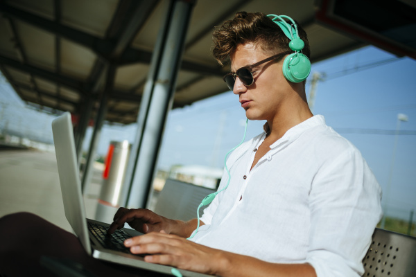 young man wearing headphones and using