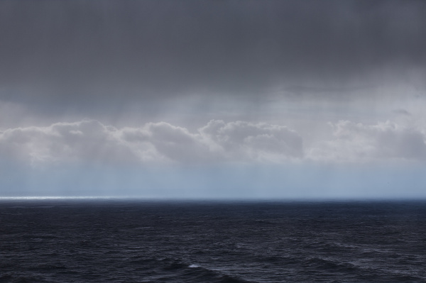 clouds and rain over ocean seascape