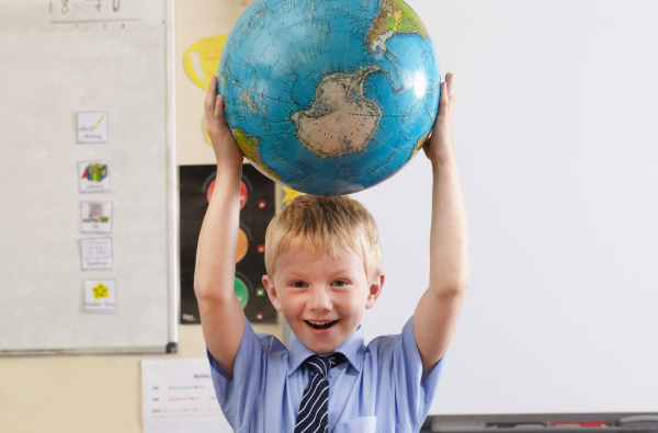 school boy holding globe over his
