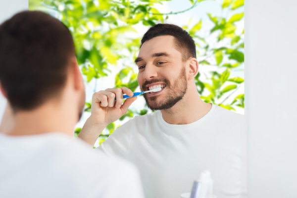 man with toothbrush cleaning teeth at