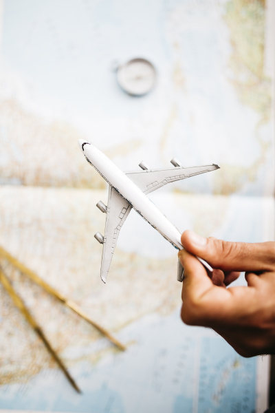 hand holding airplane model in front