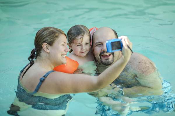 family taking selfie in swimming pool