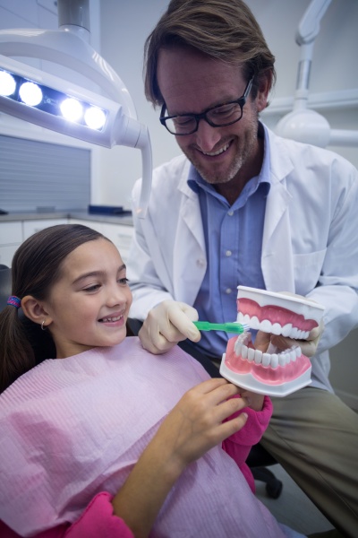 dentist showing young patient how to