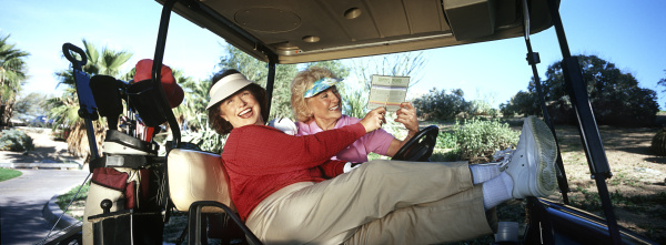 two women laughing in golf cart