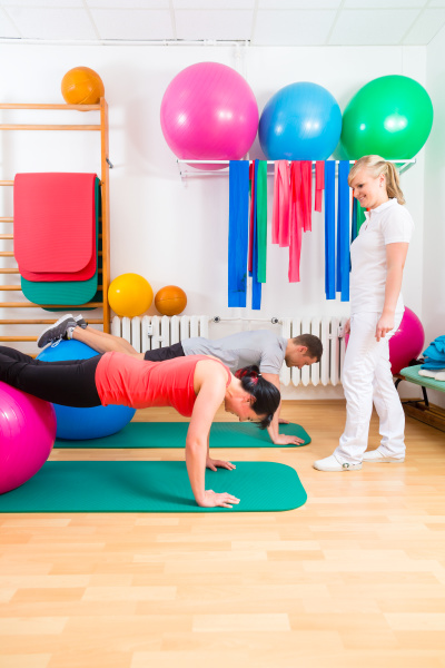 Physiotherapist giving patients gymnastic exercise - Royalty free image ...