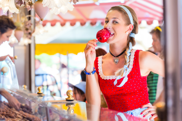woman eating candy apple at oktoberfest