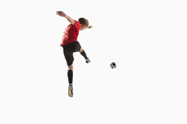 athlete kicking soccer ball