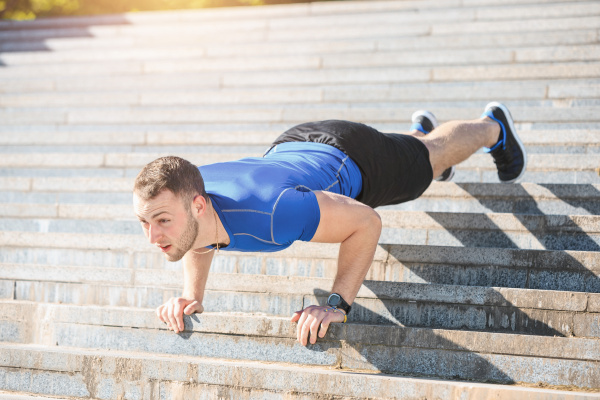 fit man doing exercises outdoors at