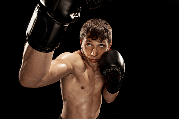 male-boxer-boxing-in-punching-bag-with-dramatic-edgy-stock-photo