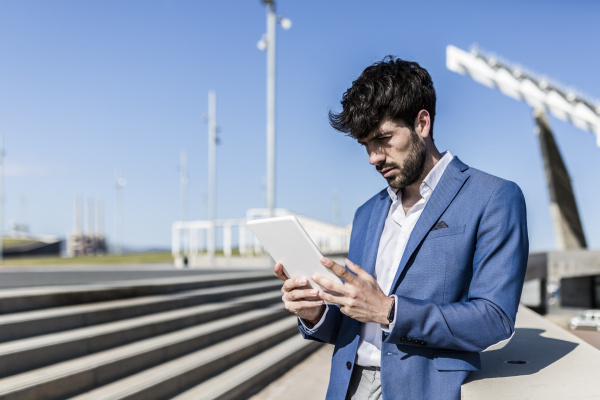 young businessman using tablet outdoors