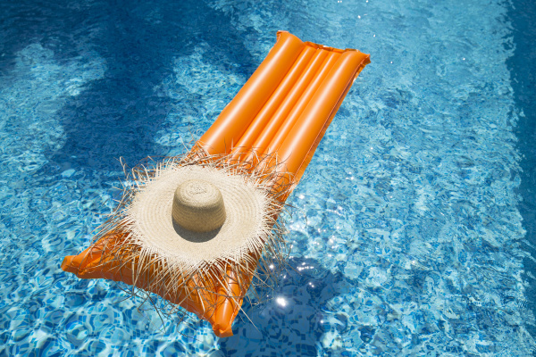 straw hat on orange airbed in