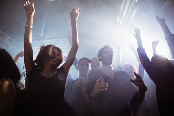 happy people dancing at nightclub
