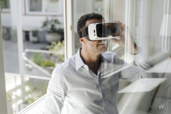 businessman at the window wearing vr