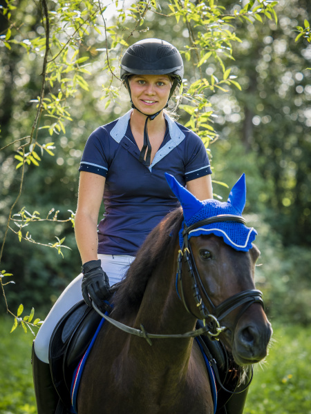 smiling young woman horseriding on field