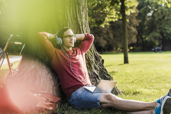man with laptop and headphones relaxing