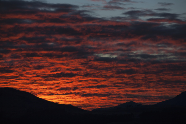 dramatic red sunset over silhouetted landscape