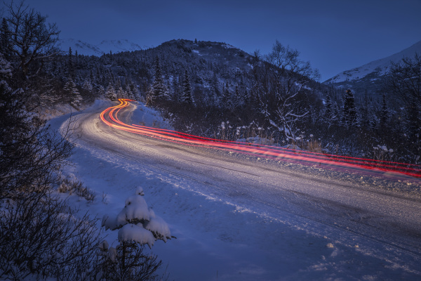vehicle taillight trails on a snowy