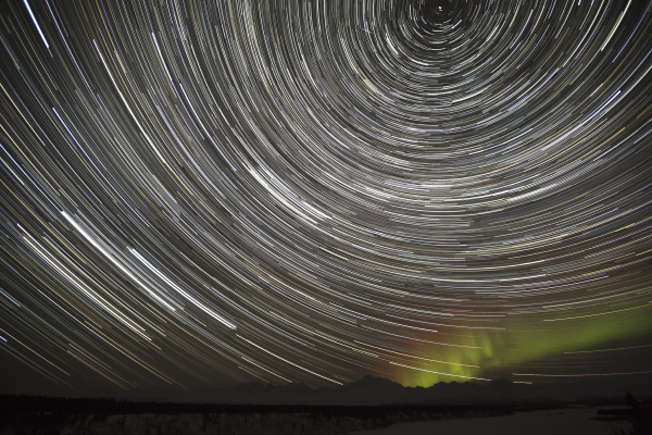 star trails and northern lights above