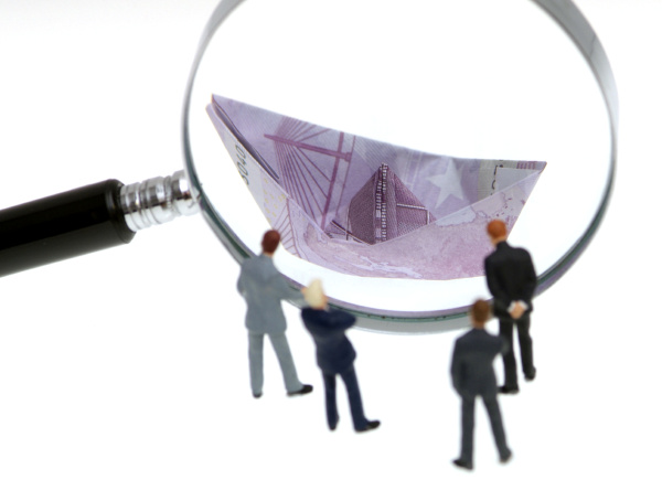 business people look through a magnifying