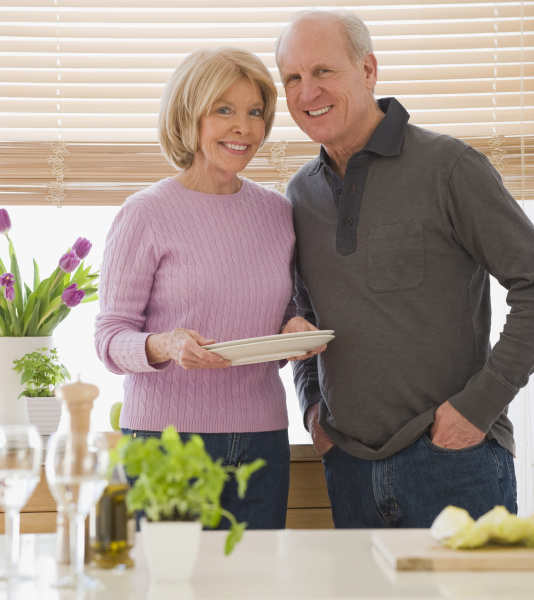senior couple with dishes in kitchen