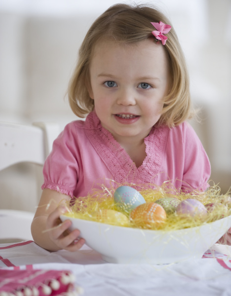 young girl holding bowl of easter