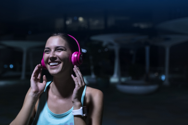 happy young woman with pink headphones