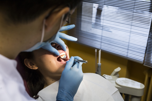 close up of dentist examining woman