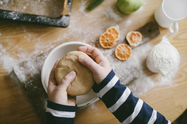 cropped hands of woman kneading dough