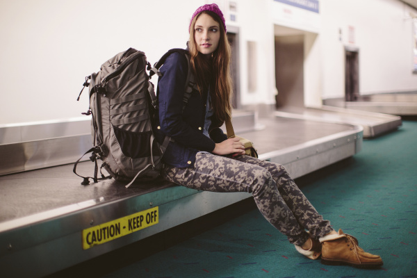 woman with luggage sitting on baggage