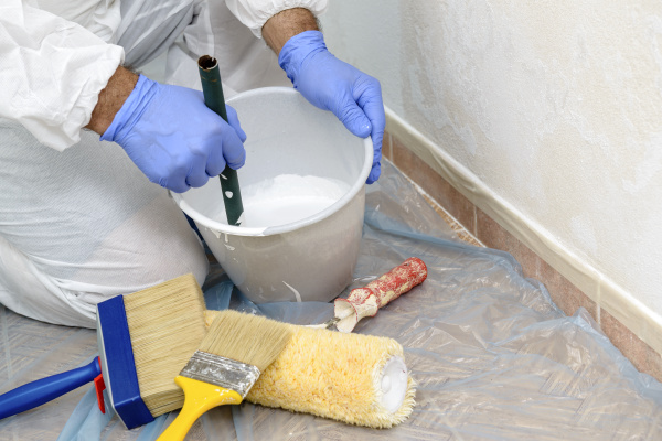 painter paints the wall with the