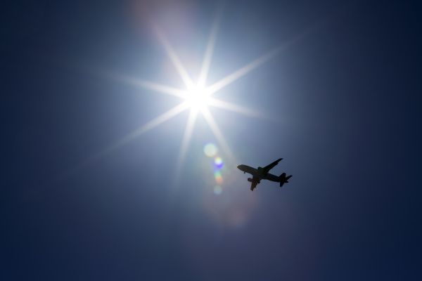 silhouette of airplane against a sunburst