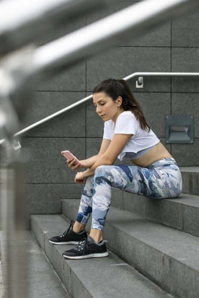 fit young woman sitting on stairs