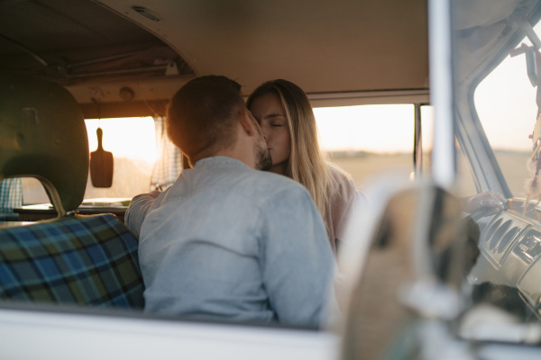 young couple kissing in camper van