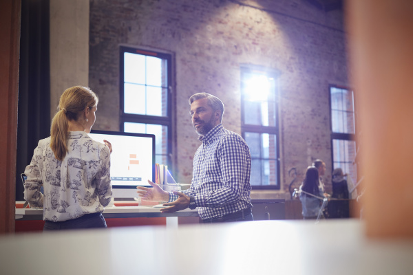 businessman and woman discussing decisions in