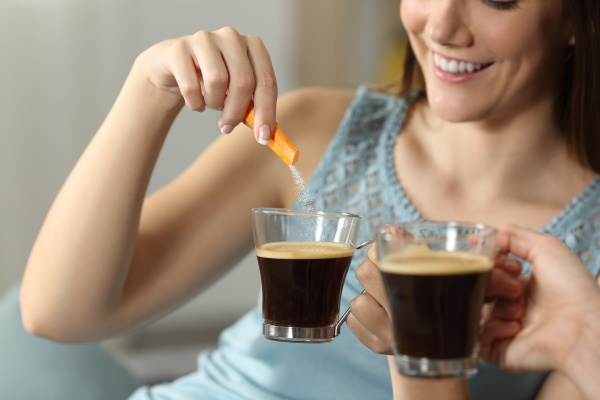 two women throwing sugar into coffee