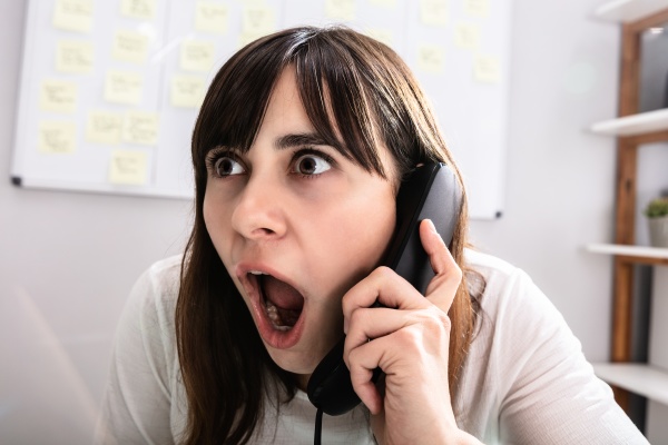 shocked businesswoman talking on telephone