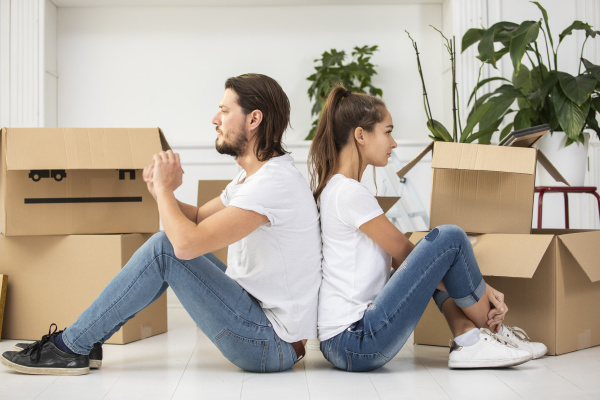 couple with cardboard boxes sitting on