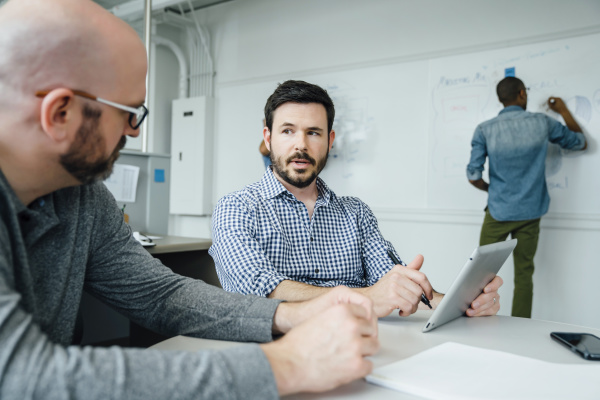 men using digital tablet during meeting
