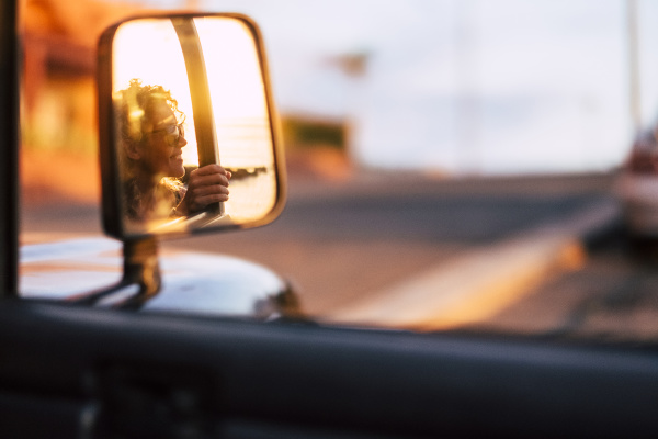 reflection in wing mirror of smiling
