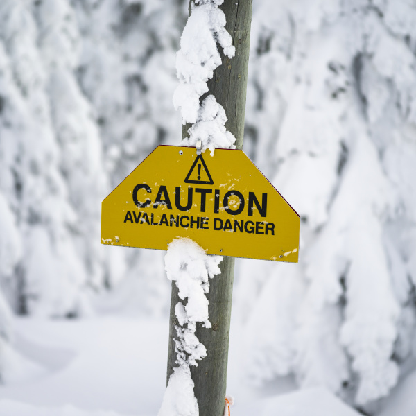 yellow caution sign warning of avalanche