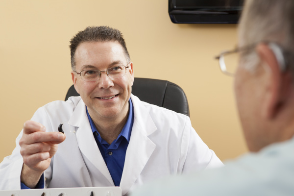 audiologist showing a hearing aid to