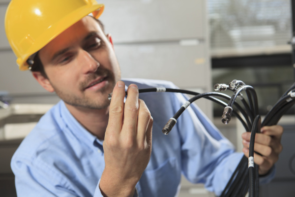 network engineer examining cable termination connector