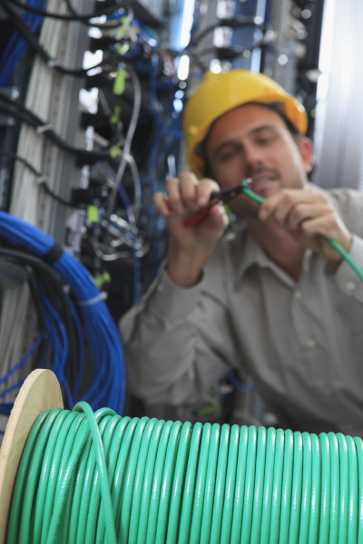 network engineer cutting cable termination in